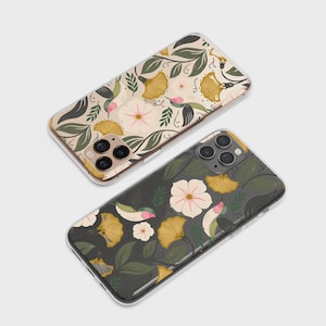 May include: Two phone cases with floral designs. One case has a cream background with yellow, green, and pink flowers. The other case has a dark green background with similar floral elements. Both cases have a clear border.