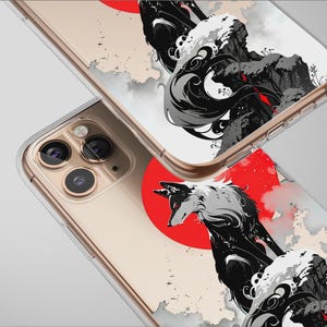Pode incluir: Capas de telefone transparentes com um design de inspiração japonesa. As capas apresentam uma ilustração de lobo a preto e branco contra um fundo de sol vermelho e montanhas. As capas têm uma moldura dourada.