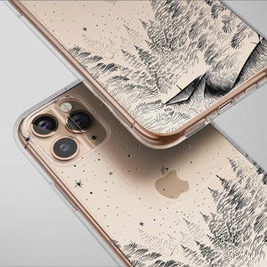 Könnte beinhalten: Transparente Handyhüllen mit einem schwarz-weißen Wald- und Bergdesign. Die Hüllen haben einen goldfarbenen Rand und eine transparente Rückseite. Das Design beinhaltet Sterne.