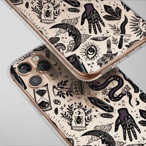 May include: Two phone cases with a mystical design featuring moons, hands, crystals, and other occult symbols in black and white. The cases have a clear border and a gold-coloured frame.