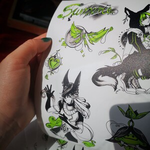 May include: A set of black and green stickers featuring a stylized illustration of a character with wolf ears and a green glowing aura. The stickers also include a heart, a flower, and the word "Summer" in cursive.
