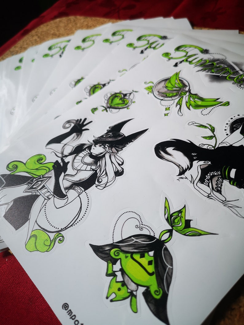 May include: A set of black and green stickers featuring a variety of designs, including a character with a hat and a green frog. The stickers are printed on white paper and have a glossy finish.