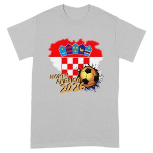 Grey t-shirt with Croatia flag, cracked soccer ball, and "NORTH AMERICA 2026" text.