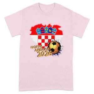Pink t-shirt with cracked soccer ball and North America 2026 text.