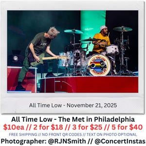 May include: A live concert photo of the band All Time Low performing on stage. The drummer is wearing a yellow shirt and white hat. The guitar player is wearing a green shirt and pants. The drum set has the band's logo. Text on the photo reads "All Time Low - The Met in Philadelphia".