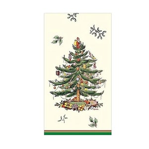 May include: A white paper napkin with a green Christmas tree decorated with ornaments, presents, and a small figure at the top. The tree is surrounded by green holly leaves and red berries. The napkin has a green and gold border.