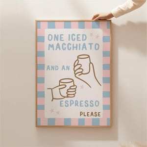 May include: A pink and blue striped poster with the text "One Iced Macchiato and an Espresso Please" with a cartoon illustration of two hands holding coffee cups.