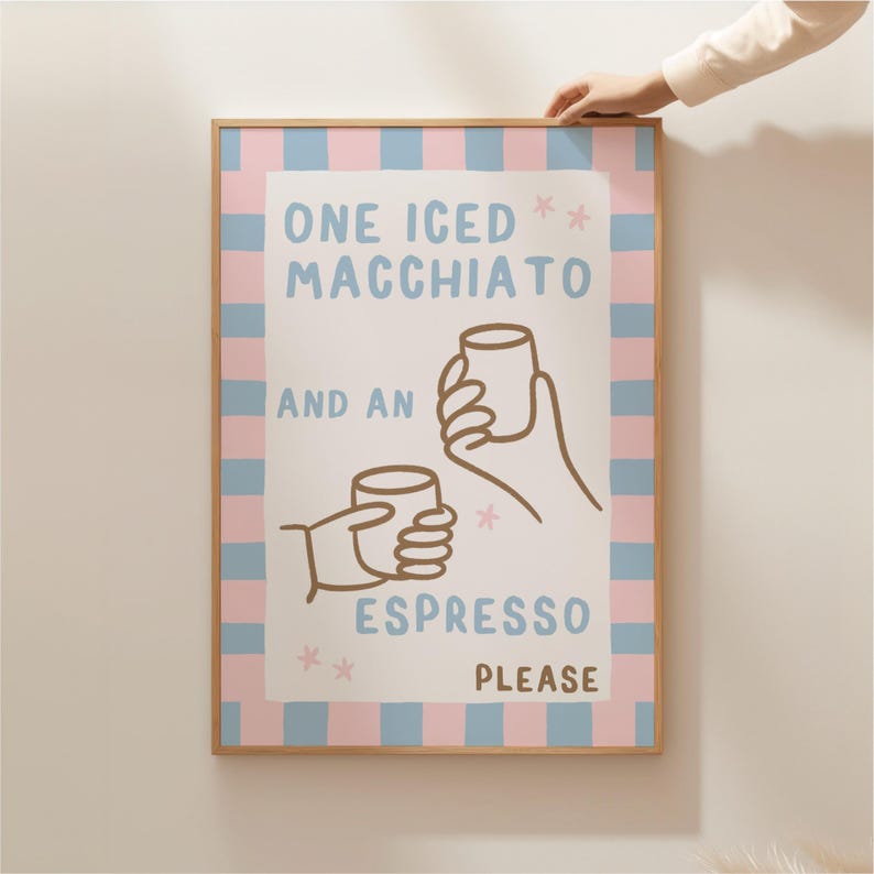 May include: A pink and blue striped poster with the text "One Iced Macchiato and an Espresso Please" with a cartoon illustration of two hands holding coffee cups.