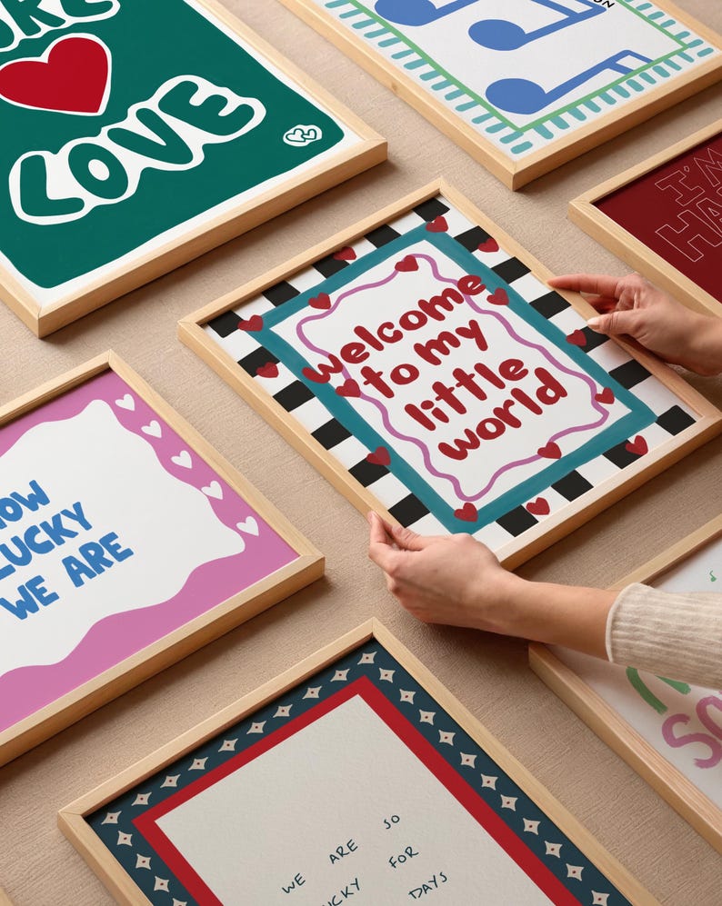 May include: A collection of eight framed prints with various designs and colors. The prints feature text such as "Welcome to my little world", "How lucky we are", and "We are so lucky for days".