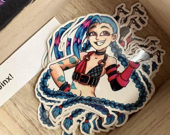 May include: A stack of die-cut vinyl stickers featuring a cartoon character with long blue braided hair, red eyes, and a wide grin. The character wears a red and black top with a belt, arm warmers, and has blue cloud tattoos on their arms.