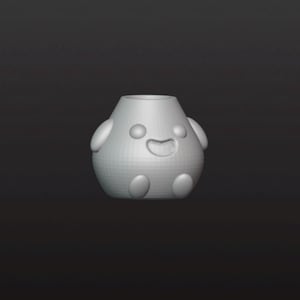 Può includere: Un personaggio simile a un cartone animato, grigio chiaro, renderizzato in 3D, con un volto sorridente. Il personaggio ha un corpo cilindrico con caratteristiche arrotondate, tra cui due occhi, una bocca e quattro piccole appendici arrotondate.