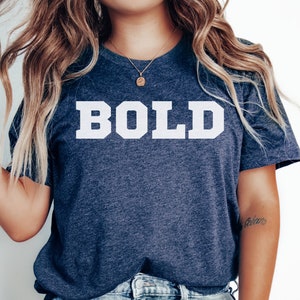 May include: A navy blue t-shirt with the word "BOLD" printed in white on the front.
