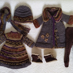 May include: A set of knitted doll clothes in brown, purple, and gold tones. The set includes a dress, a coat, a hat, a scarf, and leggings.