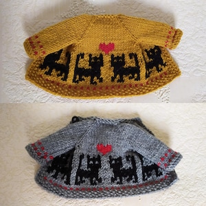 May include: Two knitted baby sweaters with a black cat design and a red heart. The sweaters are in yellow and gray.