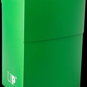 May include: A bright green card storage box with the text "Ultra PRO" in white on the top and "UP" on the side. The box is rectangular with a lid and is set against a black background.