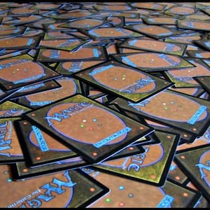 May include: A large pile of Magic: The Gathering trading cards. The cards have a brown and blue design on the back with the word "MAGIC" in a stylized font. The fronts of the cards are not visible.