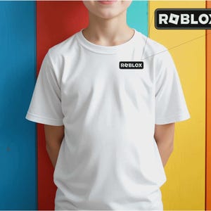 May include: A white t-shirt with the Roblox logo on the chest. The logo is a black rectangle with the word "ROBLOX" in white, and a white cube graphic. The background is a colorful vertical stripe pattern.