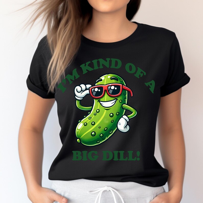 Może przedstawiać: Czarny T-shirt z zielonym kresk&oacute;wkowym og&oacute;rkiem w okularach przeciwsłonecznych i tekstem "Jestem trochę dużym og&oacute;rkiem!"