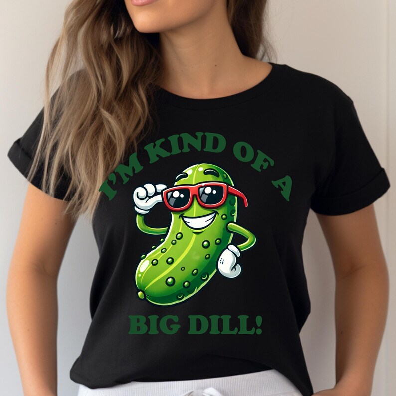 Może przedstawiać: Czarny T-shirt z zielonym kresk&oacute;wkowym og&oacute;rkiem w okularach przeciwsłonecznych i tekstem "Jestem trochę dużym og&oacute;rkiem!"