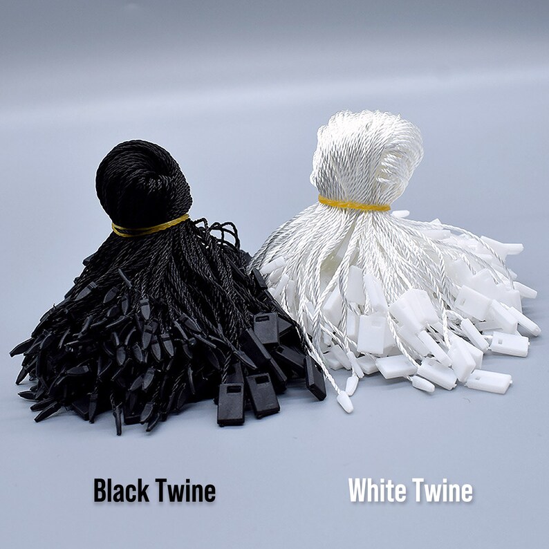May include: Two bundles of twine, one black and one white, with plastic tags attached. The black twine is labelled "Black Twine" and the white twine is labelled "White Twine".