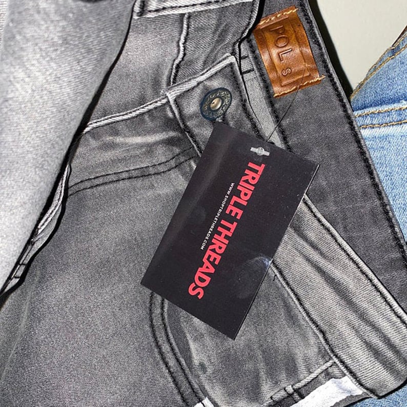 May include: Grey denim jeans with a brown leather patch that says "POLS" and a black tag that says "TRIPLE THREADS" www.triplethreads.com