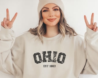 May include: A light beige sweatshirt with a distressed black graphic that says "OHIO EST 1803".