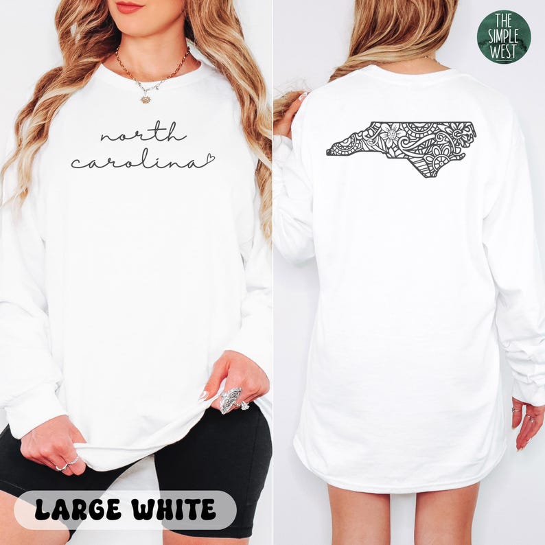 May include: White long-sleeve shirt with "north carolina" in cursive on the front. The back features a black floral design in the shape of the state. The Simple West logo is visible. The shirt is labeled "LARGE WHITE".