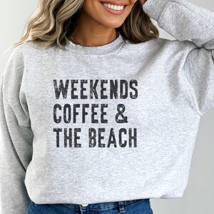 May include: A gray sweatshirt with the text "Weekends Coffee & The Beach" printed on the front.