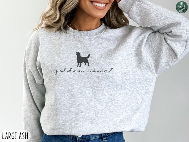 May include: Gray sweatshirt with a black silhouette of a golden retriever and the text "golden mama" in black.
