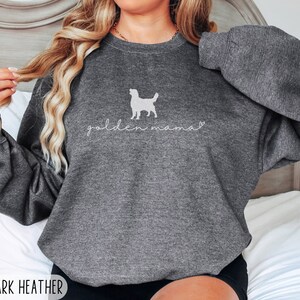 May include: A dark heather grey sweatshirt with a white silhouette of a golden retriever and the text "golden mama" in white.