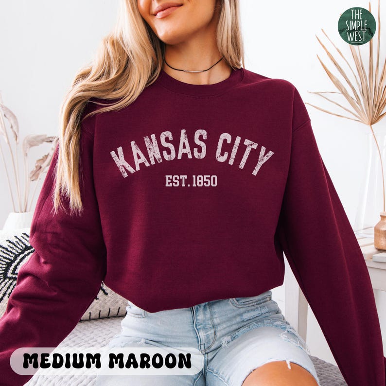 K&ouml;nnte beinhalten: Ein maroonfarbener Pullover mit dem Schriftzug "KANSAS CITY EST. 1850" in Wei&szlig;. Der Pullover ist in Gr&ouml;&szlig;e M.