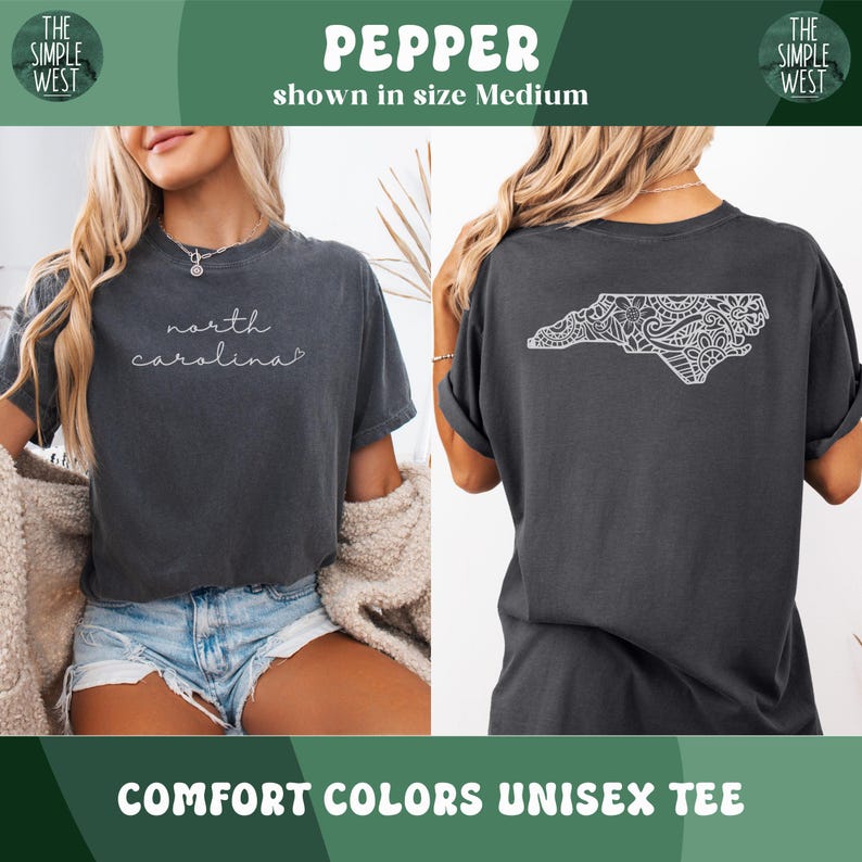May include: Pepper-colored Comfort Colors unisex tee. The front features the text "north carolina" in a cursive font. The back displays a white, detailed outline of North Carolina. The shirt is shown in size Medium.
