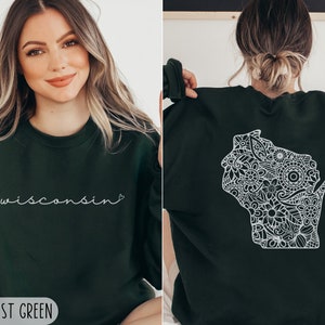 May include: A forest green sweatshirt with a white outline of the state of Wisconsin filled with a floral pattern on the back. The front of the sweatshirt has the word "wisconsin" written in white cursive with a small heart after the word. The text "2XL FOREST GREEN" is at the bottom of the image.