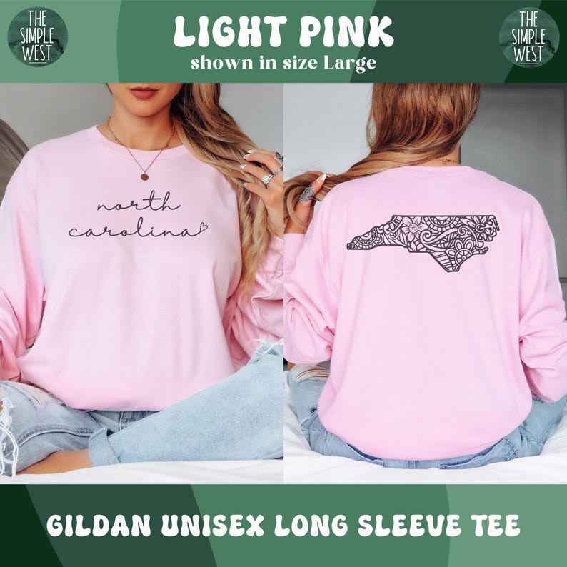 May include: Light pink Gildan unisex long sleeve tee. The front features the text "north carolina" in a script font. The back displays a black graphic of the North Carolina state outline with a decorative pattern. The shirt is shown in size Large.