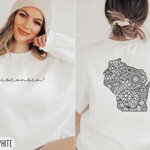 May include: White sweatshirt with the text "wisconsin" in black script on the front and a black and white mandala-style outline of the state of Wisconsin on the back. The sweatshirt is available in size large.