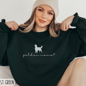 May include: A dark green sweatshirt with a white silhouette of a golden retriever and the text "golden mama" in white cursive.