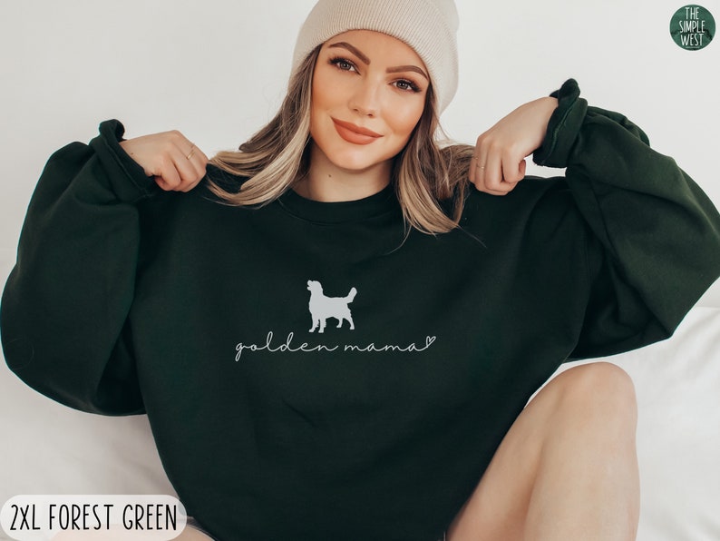 May include: A dark green sweatshirt with a white silhouette of a golden retriever and the text "golden mama" in white cursive.