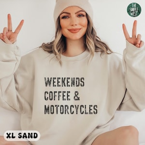 May include: A beige sweatshirt with the text "Weekends Coffee & Motorcycles" printed in black. The sweatshirt is available in size XL and the color sand.