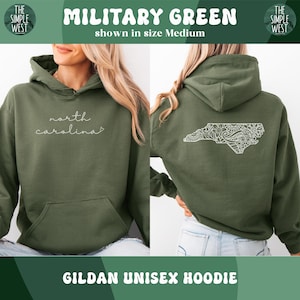 May include: Military green Gildan unisex hoodie. The front features the cursive text "north carolina". The back displays a white, detailed outline of North Carolina. The hoodie is shown in size medium.