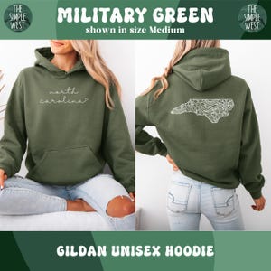 Op de afbeelding: Militairgroene Gildan unisex hoodie. De voorkant heeft de tekst "north carolina" in cursief. De achterkant toont een witte, gedetailleerde omtrek van North Carolina. De hoodie wordt getoond in maat Medium.
