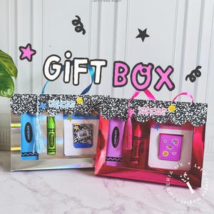 May include: Two gift boxes, one blue and silver, the other red, each with the text "GIFT BOX". Inside each box are a crayon, a lip smacker, and a notebook. The boxes are decorated with stars and confetti, with ribbons for handles.