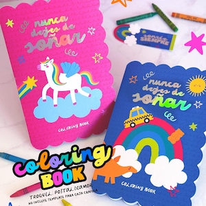 Puede incluir: Dos libros para colorear con bordes festoneados. Uno es rosa con un unicornio, un arcoíris y texto. El otro es azul con un taxi, un arcoíris y un sol. Las palabras "Coloring Book" están en una fuente colorida. El texto "nunca dejes de soñar" está en ambos libros.