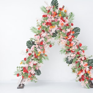 Könnte beinhalten: Ein Blumenbogen aus rosa, roten und weißen Blüten mit grünen Blättern. Der Bogen besteht aus künstlichen Blumen und ist perfekt für eine Hochzeit oder andere besondere Anlässe.