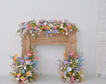 Composizione floreale da caminetto e da pavimento con fiori di campo dai toni pastello: decorazioni rosa tenue, pesca e lavanda.