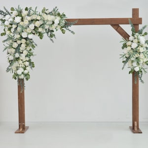 Composizione di nozze verde con fiori di rose bianche, arco nuziale