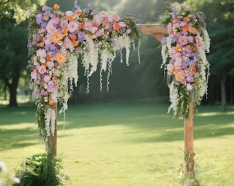 May include: A wooden wedding arch decorated with a dense arrangement of flowers in shades of pink, orange, and lavender, accented with cascading white wisteria and green foliage. The floral display covers the top and sides of the structure.