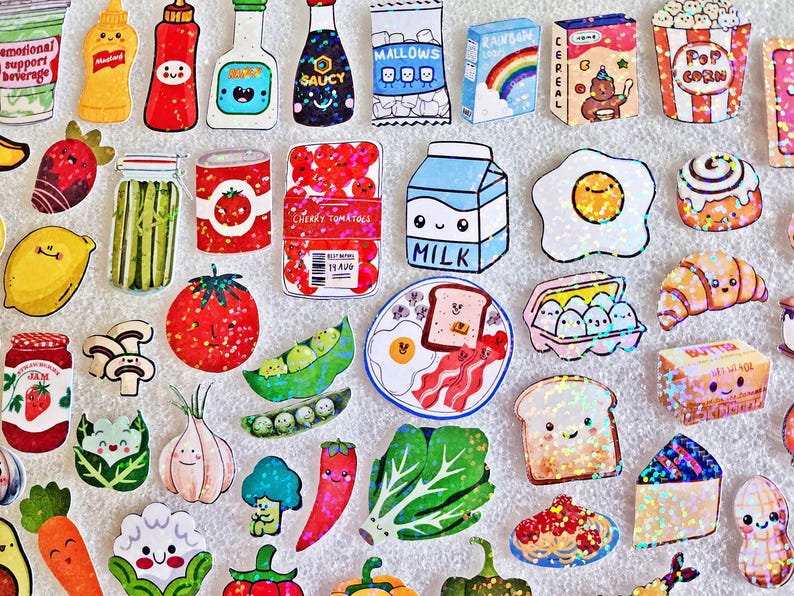May include: A collection of colorful, cartoon-style food stickers, including a carton of milk, a fried egg, a slice of toast with bacon, and various fruits and vegetables. The stickers have a glittery effect.