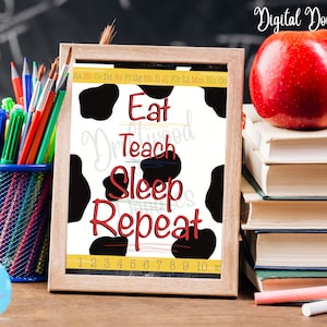 Puede incluir: Una impresión enmarcada con un fondo de estampado de vaca en blanco y negro. El texto "Eat Teach Sleep Repeat" está escrito en rojo y blanco. Los números del 1 al 10 están escritos en negro en la parte inferior de la impresión.