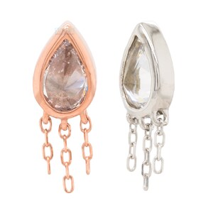 May include: A pair of teardrop-shaped earrings with a clear stone and dangling chains. One earring is rose gold and the other is silver.