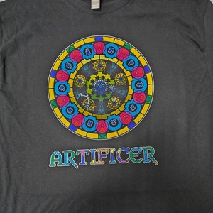 May include: A dark gray t-shirt with a colorful circular design and the word "ARTIFICER" printed in rainbow colors.